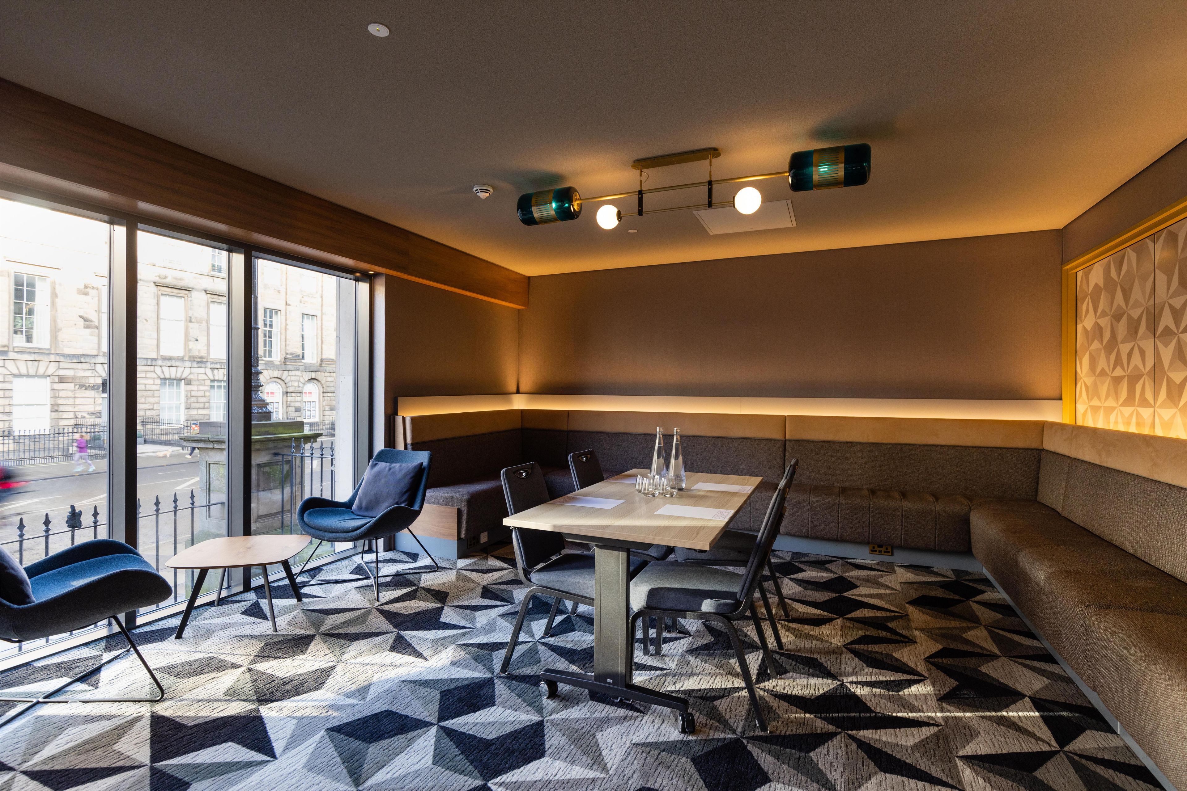 Een modern interieur met een eethoek, zitplaatsen en grote ramen.