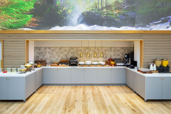 A modern kitchen with grey cabinets, a wooden countertop, and a waterfall mural on the wall. - YOTEL Edinburgh (Edinburgh)