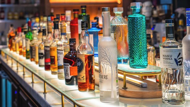 A bar with a variety of liquor bottles displayed on a counter.