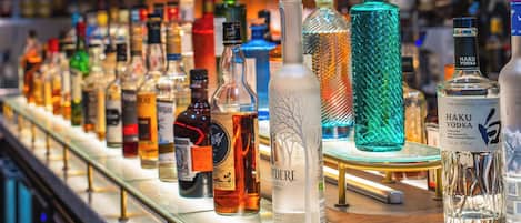 A bar with a variety of liquor bottles displayed on a counter.