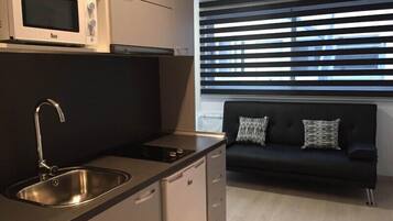 Een koelkast met diepvriezer, een microgolfoven, een kookplaat