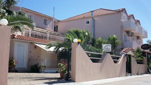 A building with a beige facade, a tiled roof, and a sign indicating 'Sterna Studios 41005'. - Katerina Studios (Kefalonia)