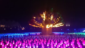 Un árbol con luces de colores y un suelo con diseño.