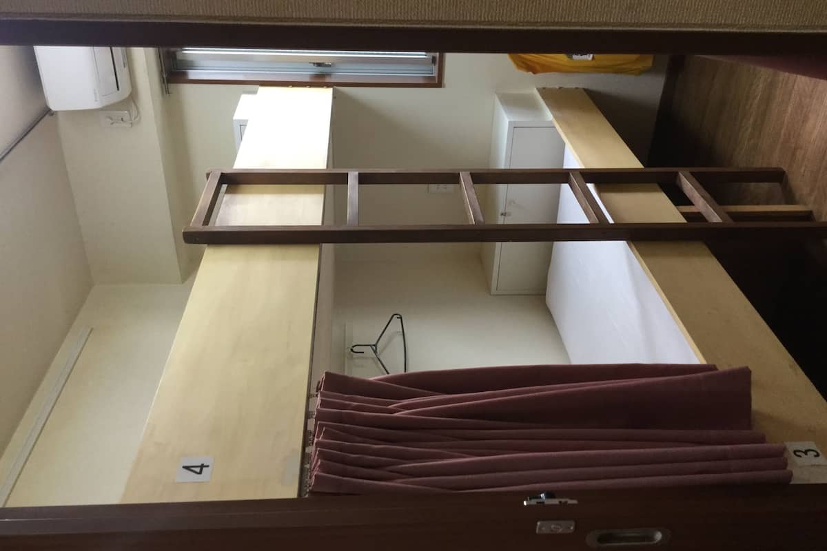 A bunk bed with a ladder, a desk, and a chair.