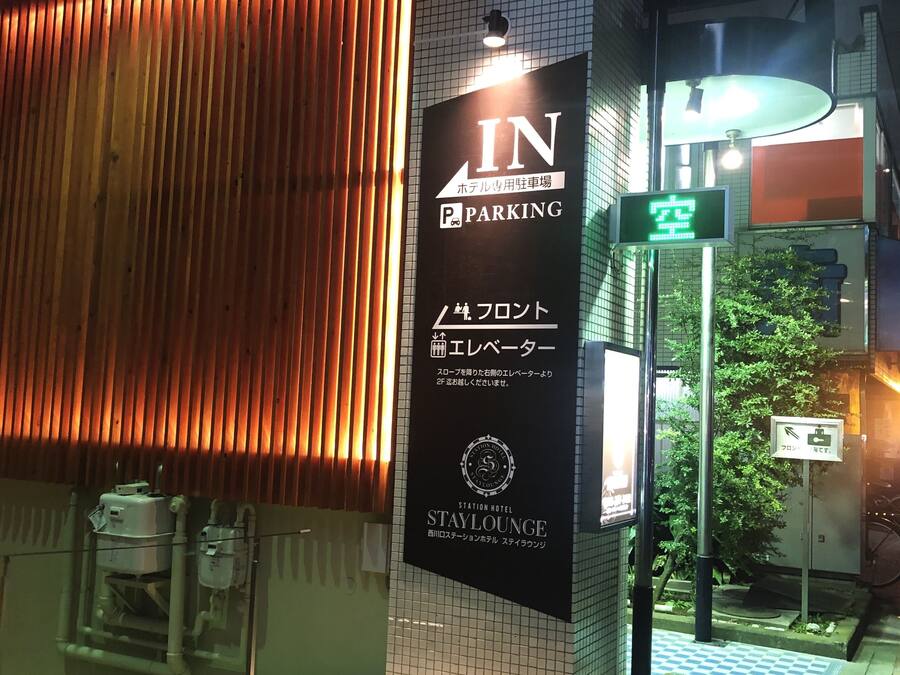 A hotel entrance with a sign indicating a parking area.