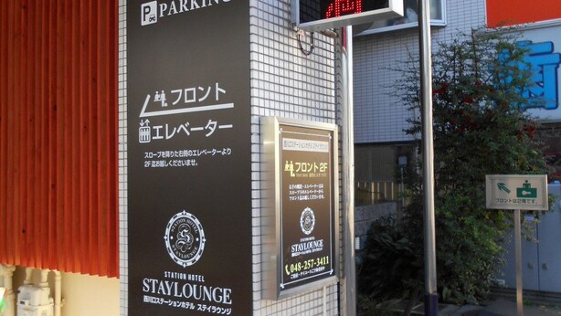 A hotel entrance with a sign indicating 'IN PARKING' and a digital display. - Nishikawaguchi Station Hotel Stay Lounge (Kawaguchi)