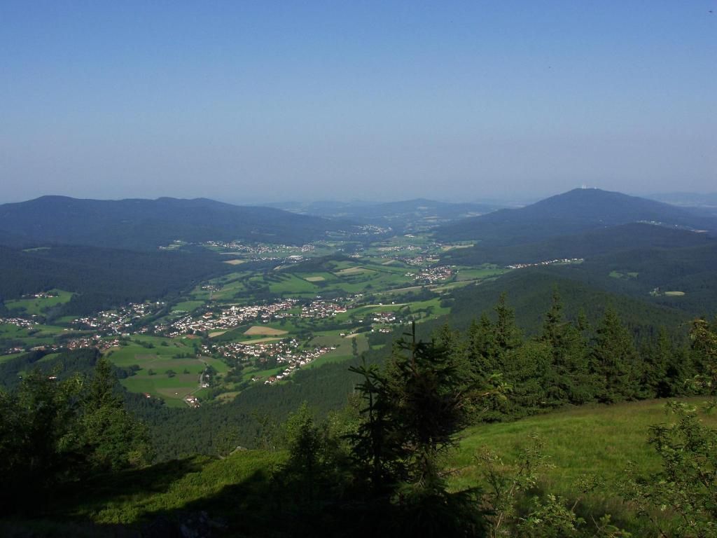 A panoramic view of a valley with a town nestled among hills.