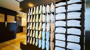A wall with neatly folded towels in various colors and a wooden panel design. - Super Hotel Sakai Marittima (Sakai)