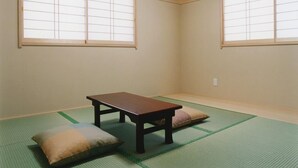 A traditional Japanese room with tatami flooring, a low wooden table, and shoji screens.