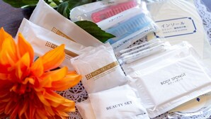 A variety of personal care products arranged on a lace tablecloth. - Niiza Daily Hotel (Niiza)