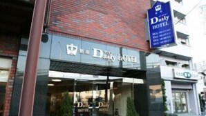 A hotel entrance with a glass facade, a signboard, and potted plants. - Niiza Daily Hotel (Niiza)