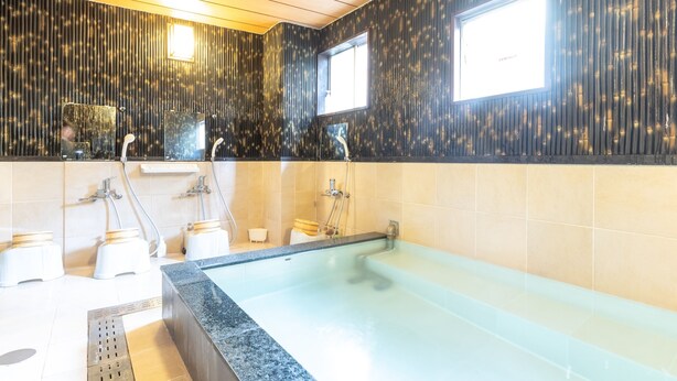 A modern bathroom with a large bathtub, a shower area, and a vanity with a mirror. - Business Ryokan Akashiya Annex (Akashi)