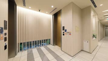 A modern interior with a checkered floor, a glass partition, and informational signs on the walls.
