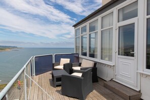 Terraza con mobiliario de mimbre y vista al mar.