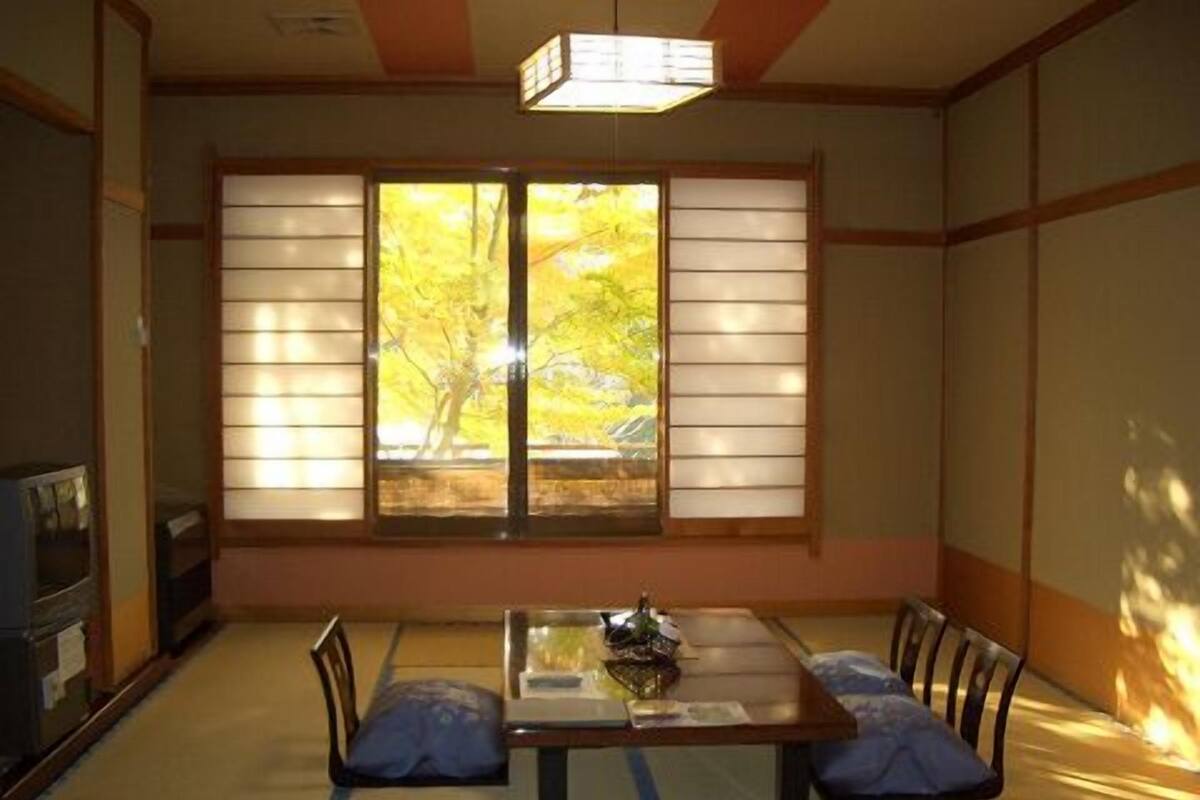 A traditional Japanese room with tatami flooring, a low table, and sliding shoji doors.