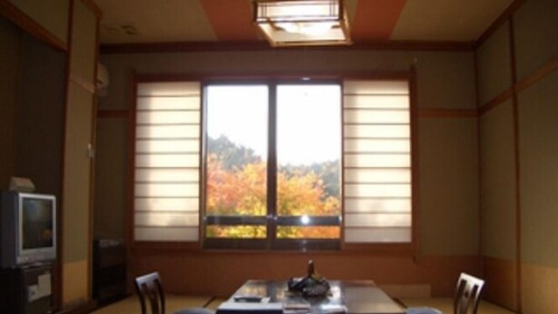 Una habitació tradicional japonesa amb paviment de tatami, una taula baixa i portes corredisses shoji.