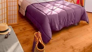 A cozy room with a bed, a small desk, and a window with curtains. - Camping le Beauvillage - Yourte (Lauzerte)