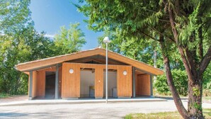 A modern building with a wooden facade, large windows, and a covered entrance area. - Camping le Beauvillage - Yourte (Lauzerte)