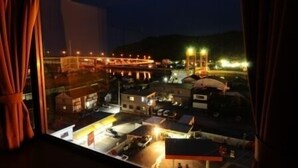 A nighttime view of a town with illuminated buildings and a bridge.