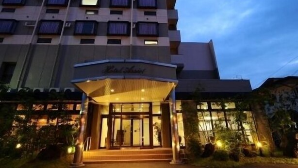 A hotel entrance with a covered porch and a sign above it.