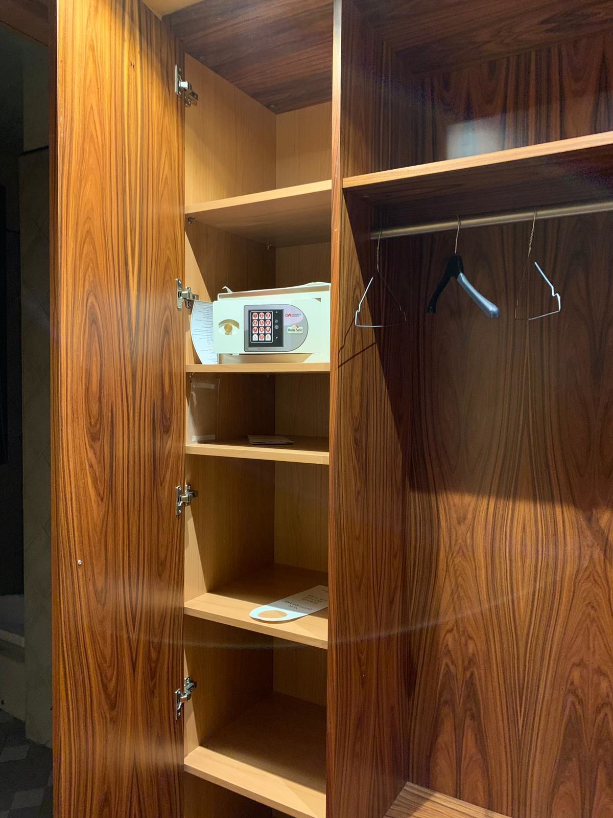 Un armario de madera con varios estantes y una barra para colgar.