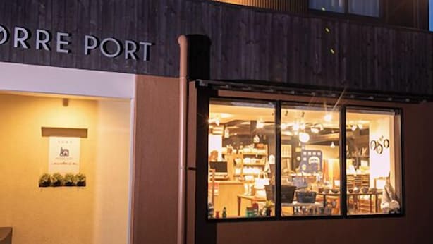A storefront with the sign "ORRE PORT" and large glass windows displaying various items inside. - Personal Hotel You (Takeo)