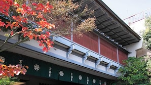 A vintage red truck parked in front of a building with a green awning and a sign with Japanese characters. - Personal Hotel You (Takeo)
