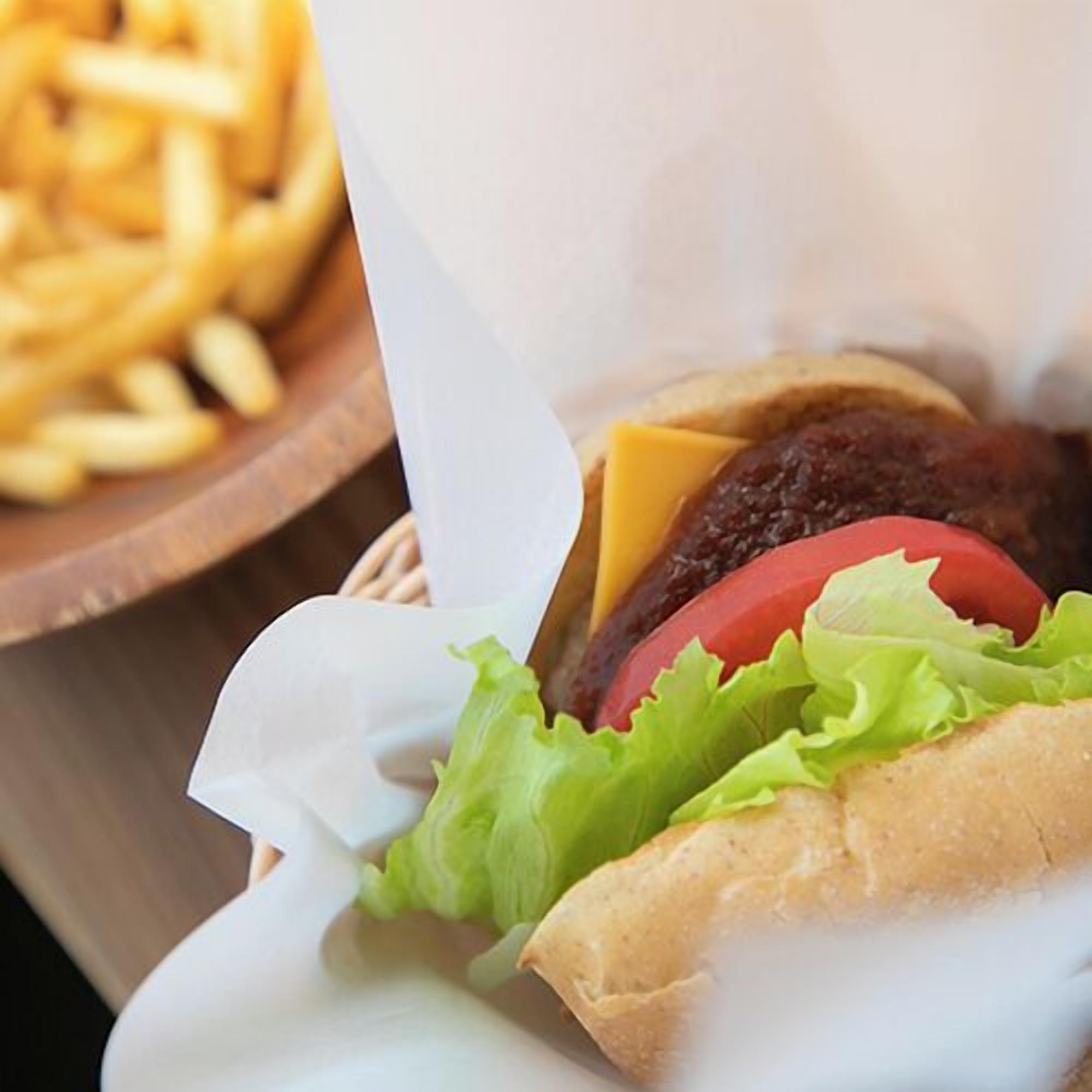 A burger with lettuce, tomato, and cheese, and a side of fries.