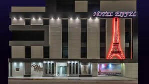 A hotel with a prominent Eiffel Tower sign and a modern facade. - Hotel Eiffel (Ensenada)