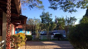 Un camino de adoquines que conduce a una casa con fachada azul y un porche de madera.