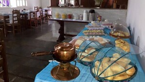 Un comedor con mesas de buffet, que incluye una tetera de cobre y presentaciones de comida cubiertas.