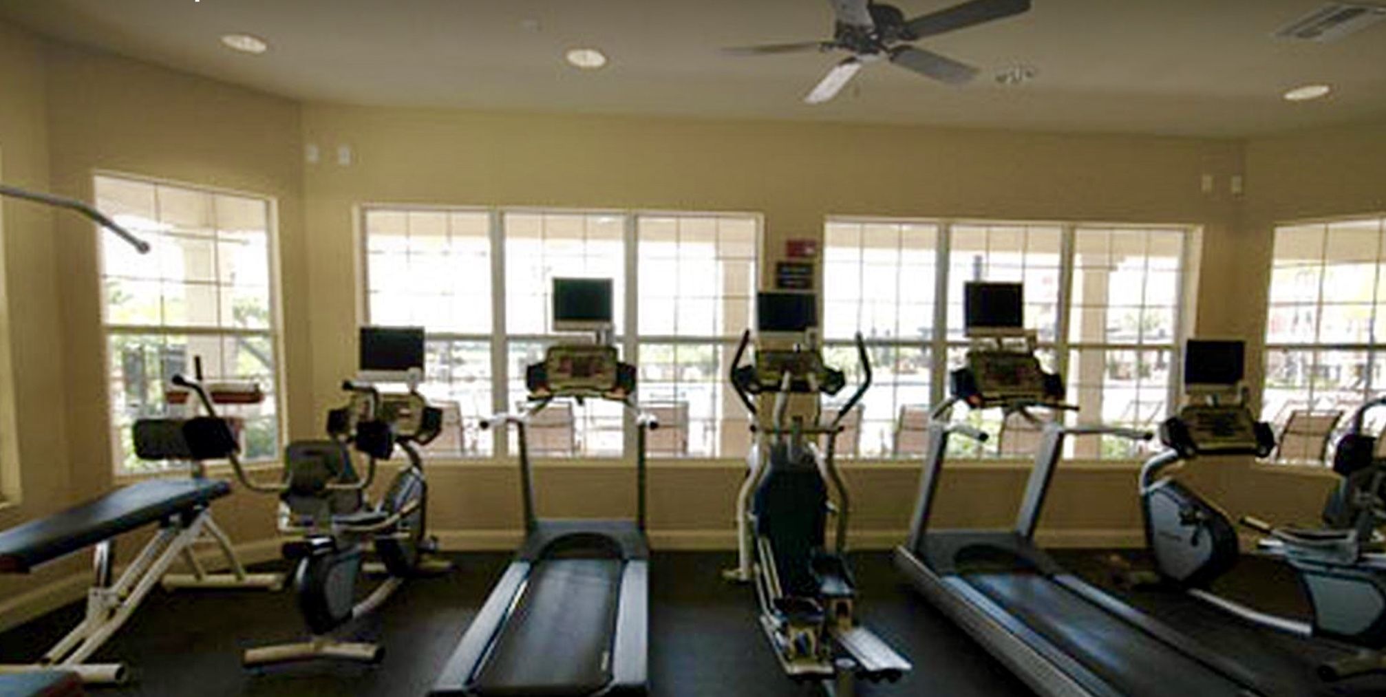 A gym with treadmills, stationary bikes, and a rowing machine.