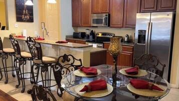 A kitchen with wooden cabinets, a stainless steel refrigerator, a microwave, and a coffee maker.