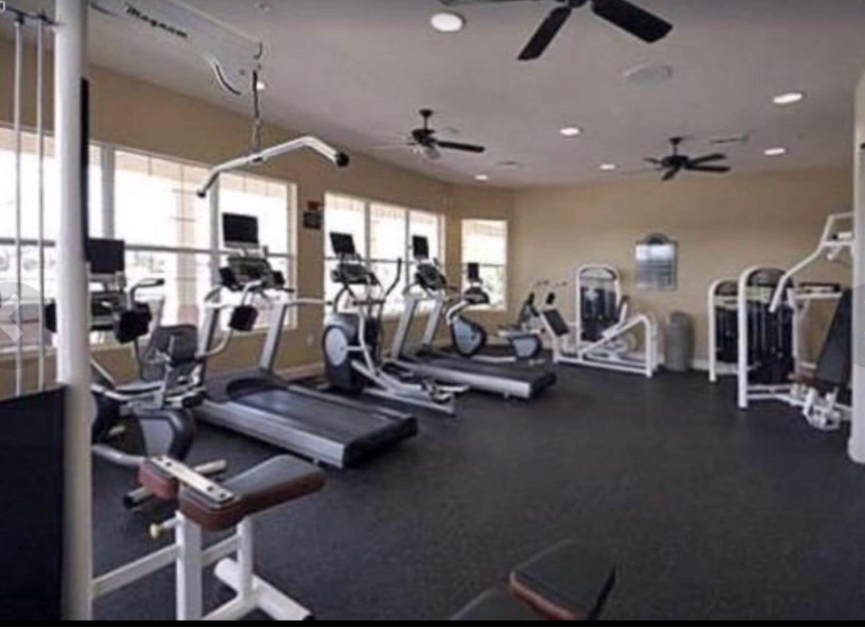 Una palestra con tapis roulant, macchinari ellittici e attrezzature per pesi.