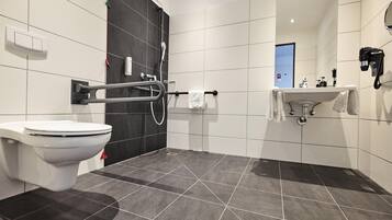 Un baño moderno con inodoro, ducha y lavamanos.