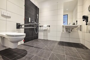Un baño moderno con inodoro, ducha y lavamanos.