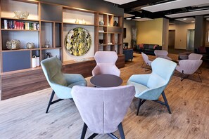 Un área de lounge moderna con asientos, estanterías y obras de arte.