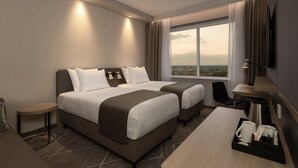 A modern hotel room with two beds, a desk, a chair, a coffee maker, and a view of the city. - Holiday Inn Eindhoven Airport by IHG (Eindhoven)
