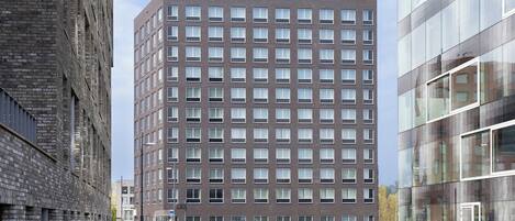 A modern building with a brick facade and multiple windows.