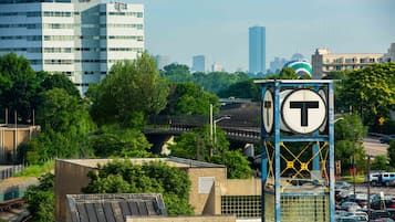 Ein mit T-Logo versehener Glockenturm, umgeben von städtischen Gebäuden und Grünflächen.