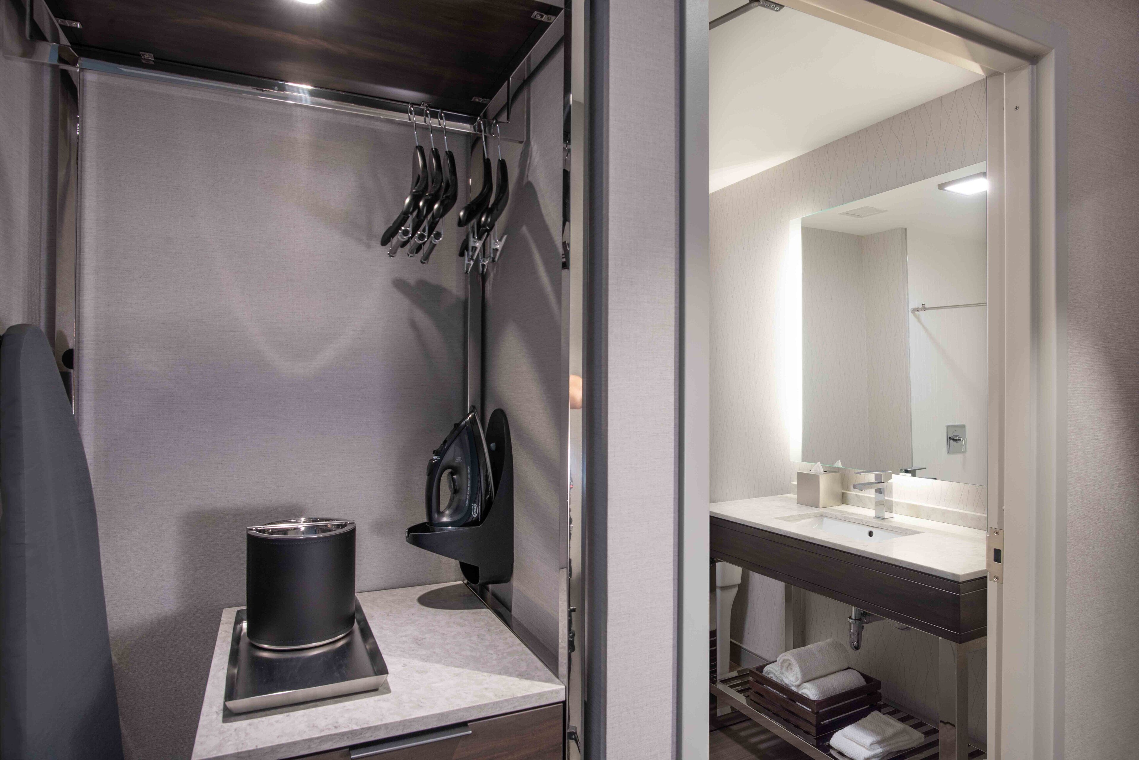 A compact bathroom with a sink, mirror, and towel rack.