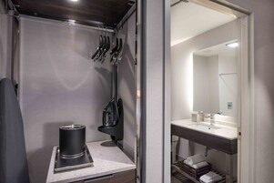Un baño pequeño con lavamanos, espejo y perchero para toallas.