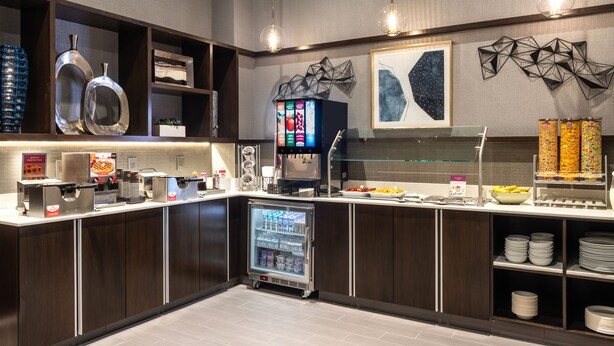 A modern kitchen with a refrigerator, coffee machine, and various food items on the counter. - Holiday Inn Express Boston South - Quincy by IHG (Quincy)
