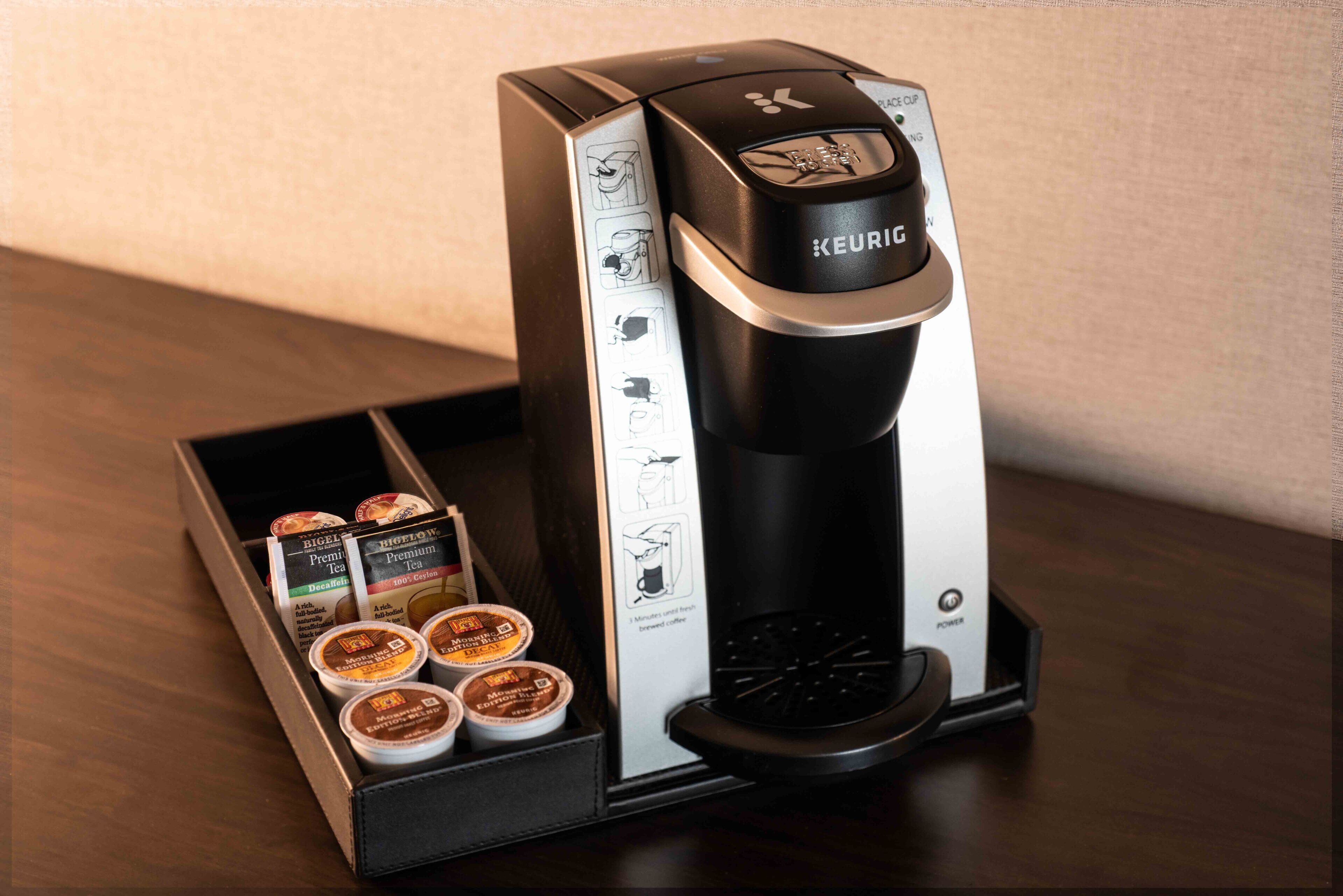 Una macchina per il caffè Keurig con un portabicchieri per capsule contenente diverse capsule.