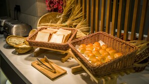 A buffet setup with bread, butter, and pastries.