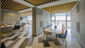 A modern conference room with a large table and chairs, a patterned floor, and a ceiling with wooden slats.
