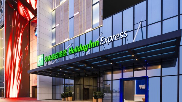 A Holiday Inn Express hotel with a modern facade, large windows, and a prominent entrance.
