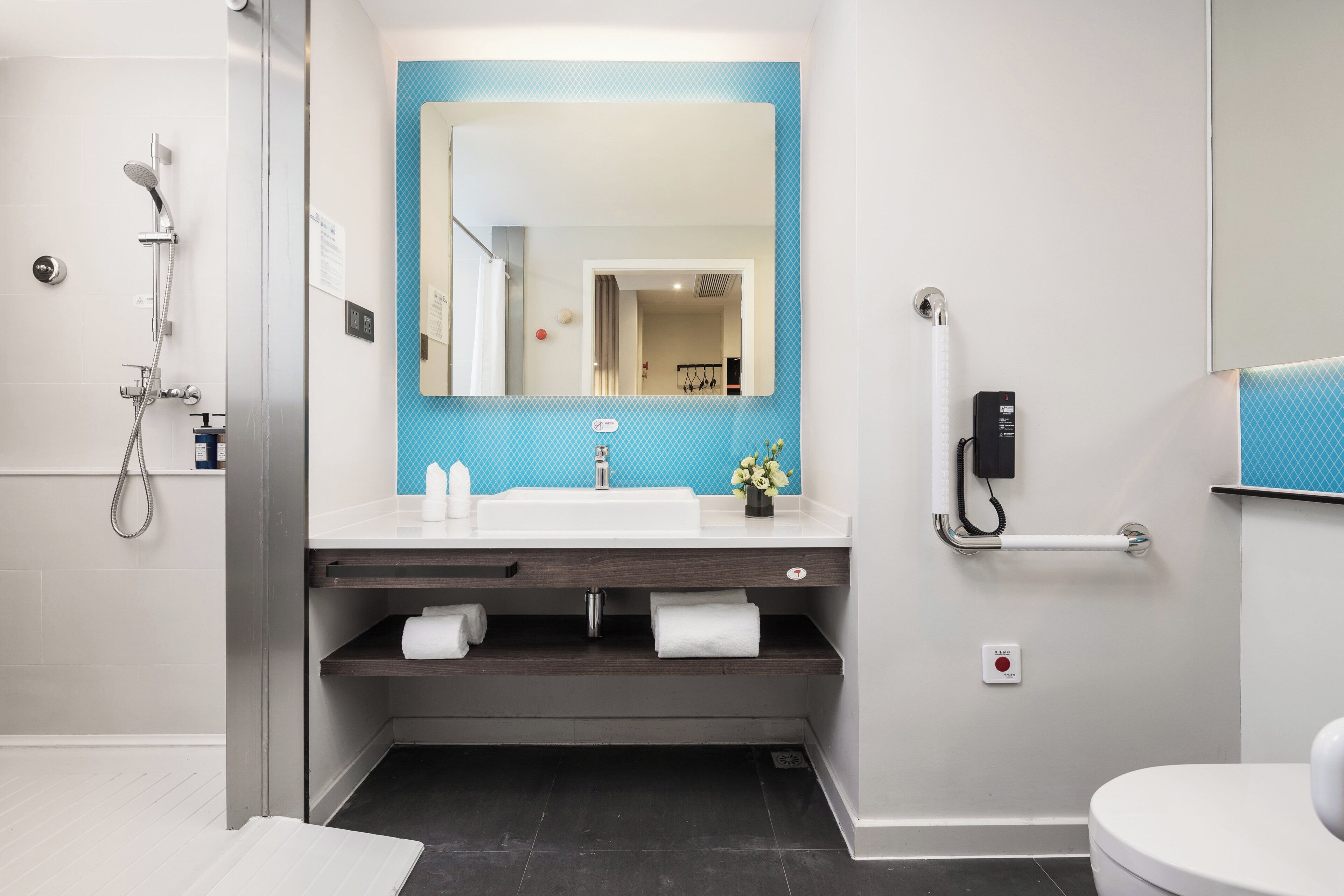 A modern bathroom with a shower, sink, and toilet.