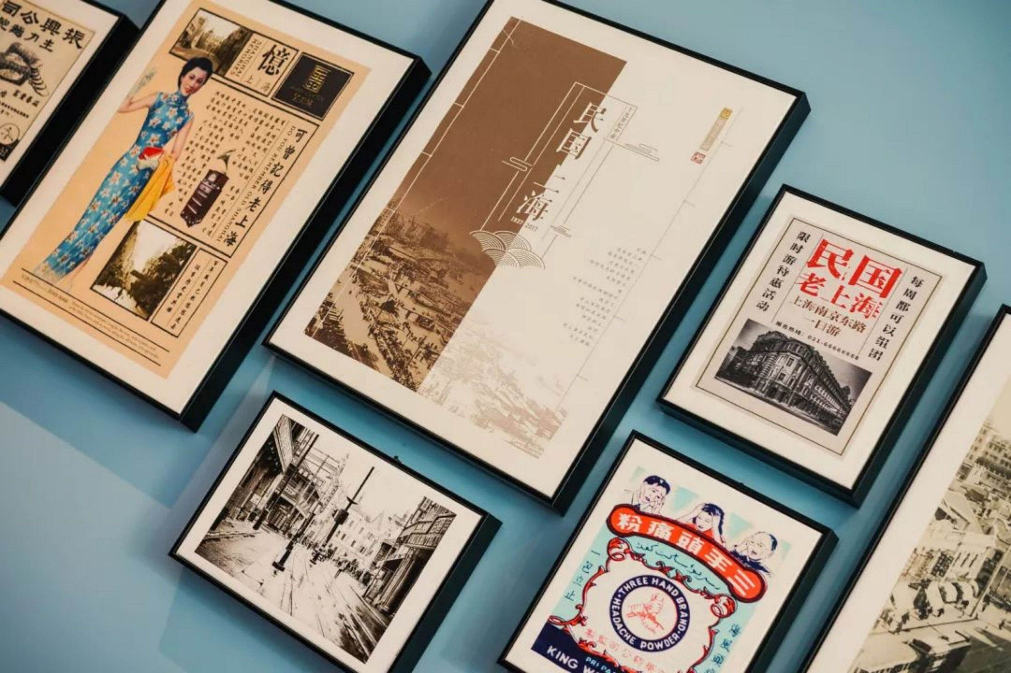 A collection of framed photographs and documents on a blue background.