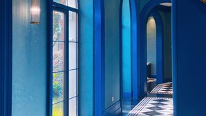Un couloir aux murs bleus et doté de grandes fenêtres.